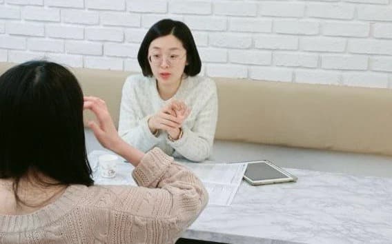 소파에 마주 앉아 상대방의 이야기를 듣는 모습