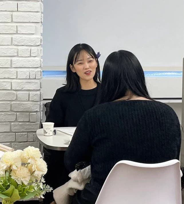 테이블을 사이에 두고 마주 앉아 이야기를 나누는 두 사람